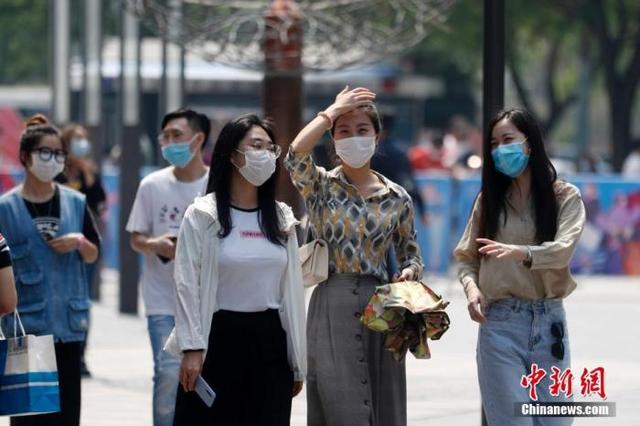 5月2日，“五一”假期的第二天，北京持续高温天气。图为民众戴口罩出行。  中新网 图