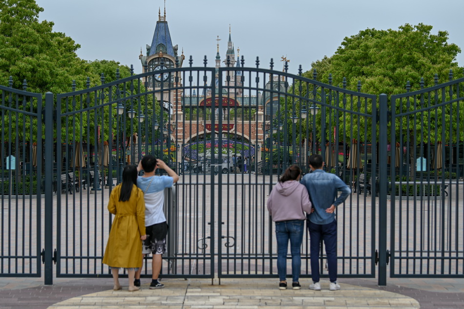 5月6日，上海迪士尼乐园，游客隔门张望园区。
