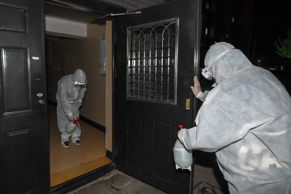 5月10日，在舒兰市一个小区，社区工作人员对楼门进行消毒。 新华社 图