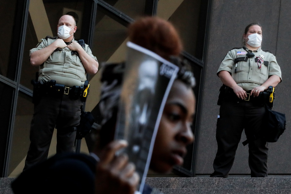 5月28日，在美国明尼阿波利斯，警察在抗议活动附近警戒。