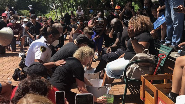 美国白人警察半跪为非裔牧师洗脚