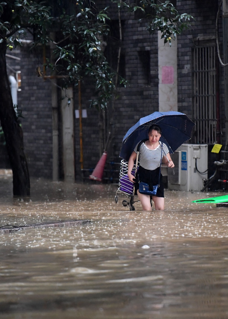 6月6日，在广西柳州街头，市民涉水出行。