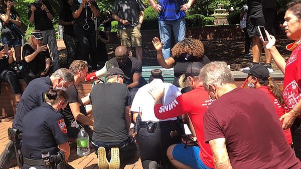 仿照圣经洗脚礼，美国白人警察跪地为非裔牧师洗脚