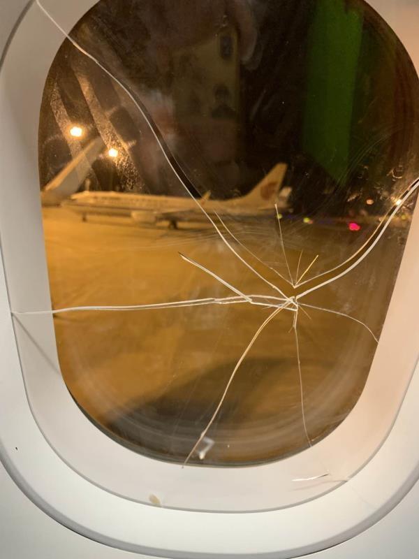 被砸裂的机舱玻璃。