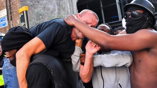 搁置争议！英国非裔男子肩扛受伤右翼白人