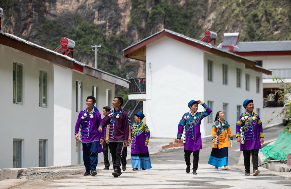 6月29日，阿布洛哈村村民身着彝族传统服饰载歌载舞庆祝通村公路通车。