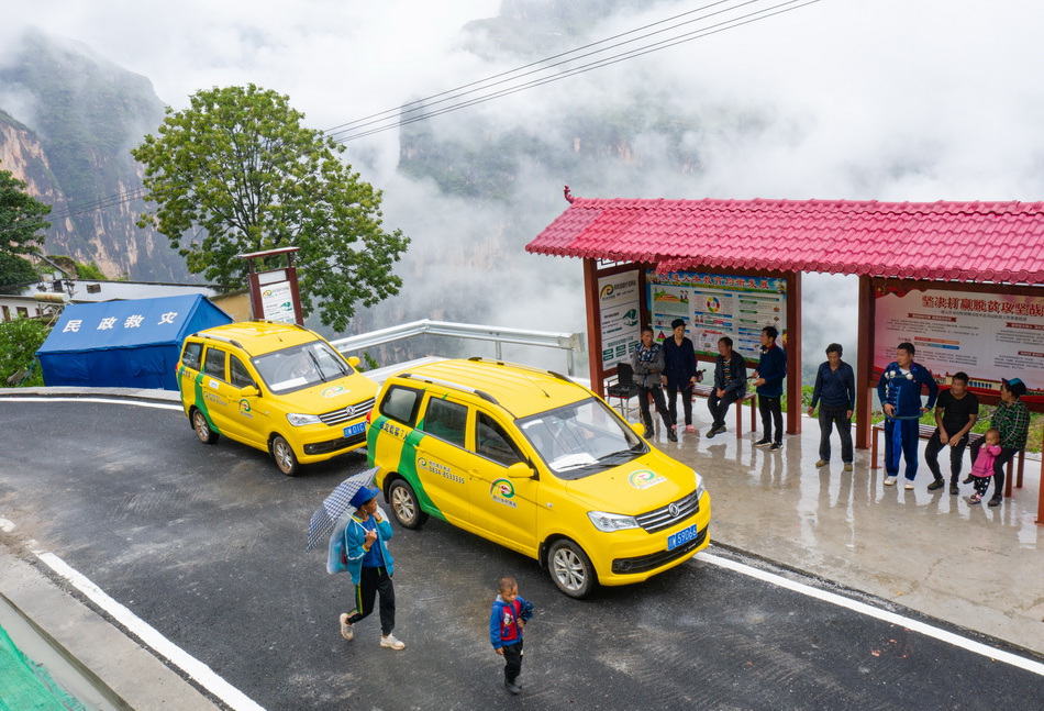 6月30日，两辆四川乡村客运面包车在阿布洛哈村等待乘客。
