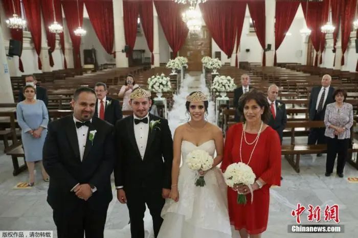 资料图：当地时间2020年6月20日，约旦安曼，当地一对新人Zaid Masarweh和Leen Aghabi在教堂举办了一场小型婚礼，并且通过Zoom软件对他们在海外的家人直播了婚礼。 