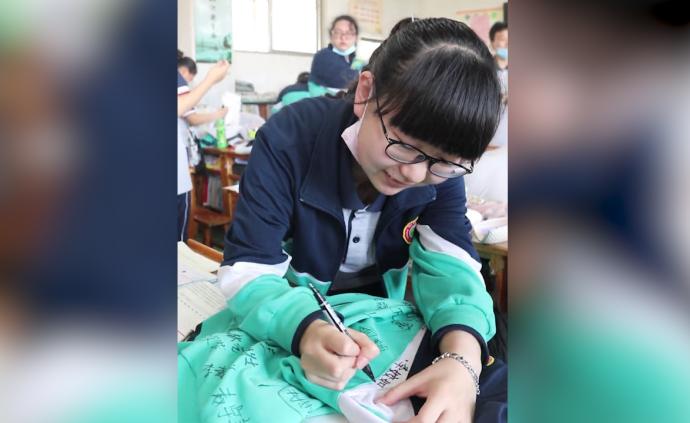 高三生离校前拿校服找老师同学签名留念：会珍藏一辈子