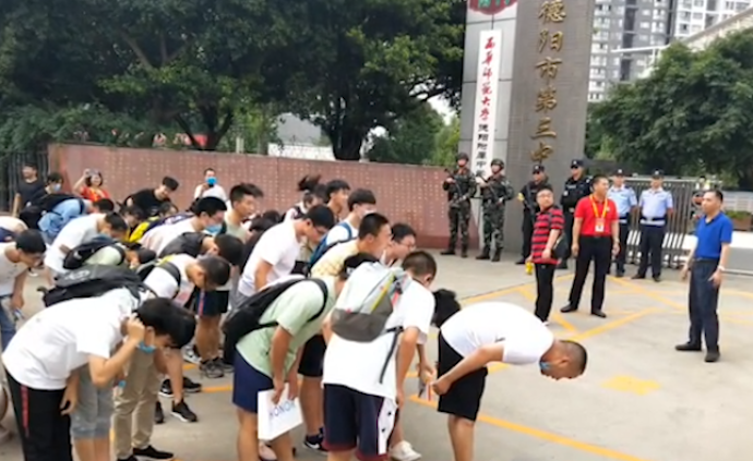 高考完出考场，学生们向警察司机鞠躬致谢