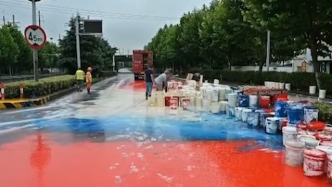 货车侧门松动甩百桶油漆，路面变“染坊”