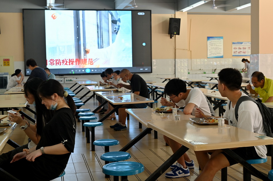 2020年7月10日，武汉睿升学校，食堂的大屏上播放着防疫知识。