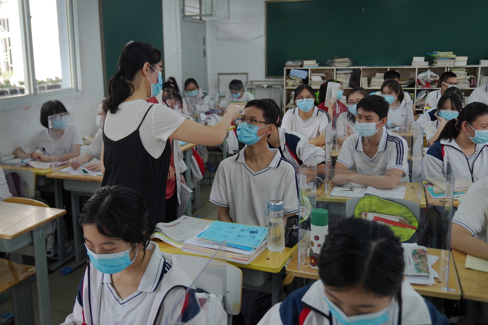 2020年7月10日，武汉市第六十八中学，老师在给学生测量体温。