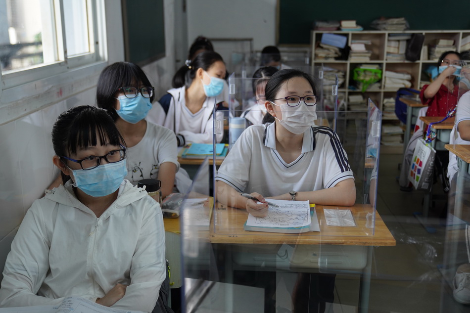 2020年7月10日，武汉市第六十八中学，学校在课桌上放置透明隔板，确保安全距离。