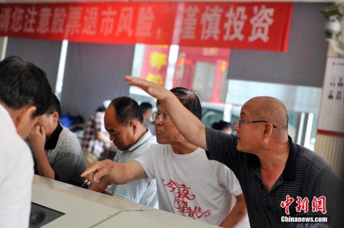 资料图:两位股民在针对股指走势激烈讨论。 中新社记者 韦亮 摄