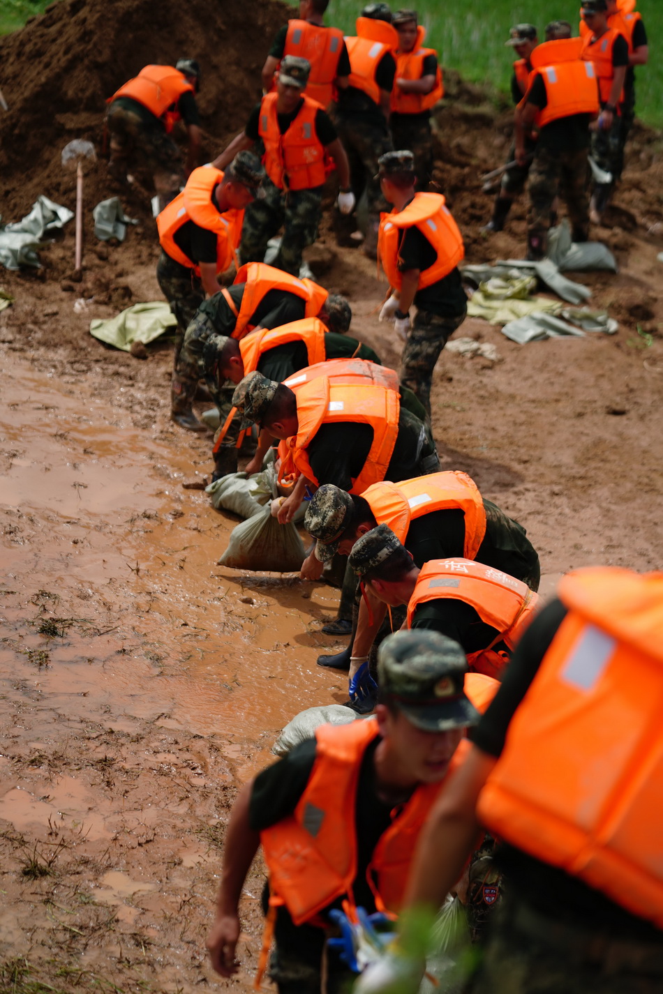 7月11日，武警战士在鄱阳县鄱阳镇江家岭村搬运沙袋。