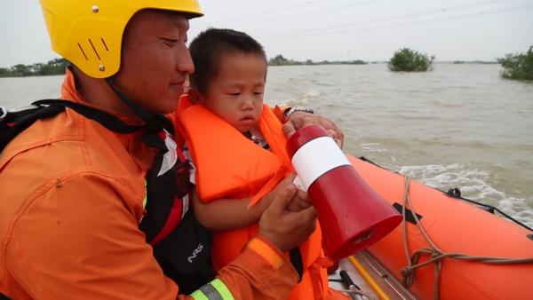 小朋友被洪水吓坏，消防员抱起安慰