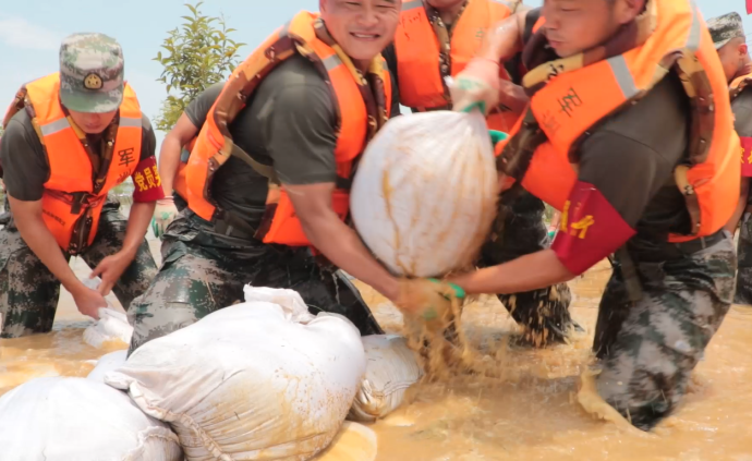 装土扛沙围堰固堤，子弟兵奋战抗洪一线