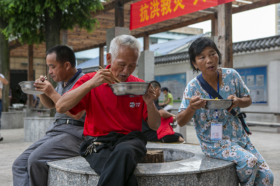 2020年7月16日，江西省鄱阳县五一中心学校安置点，安置点内的受灾民众在院子里吃饭