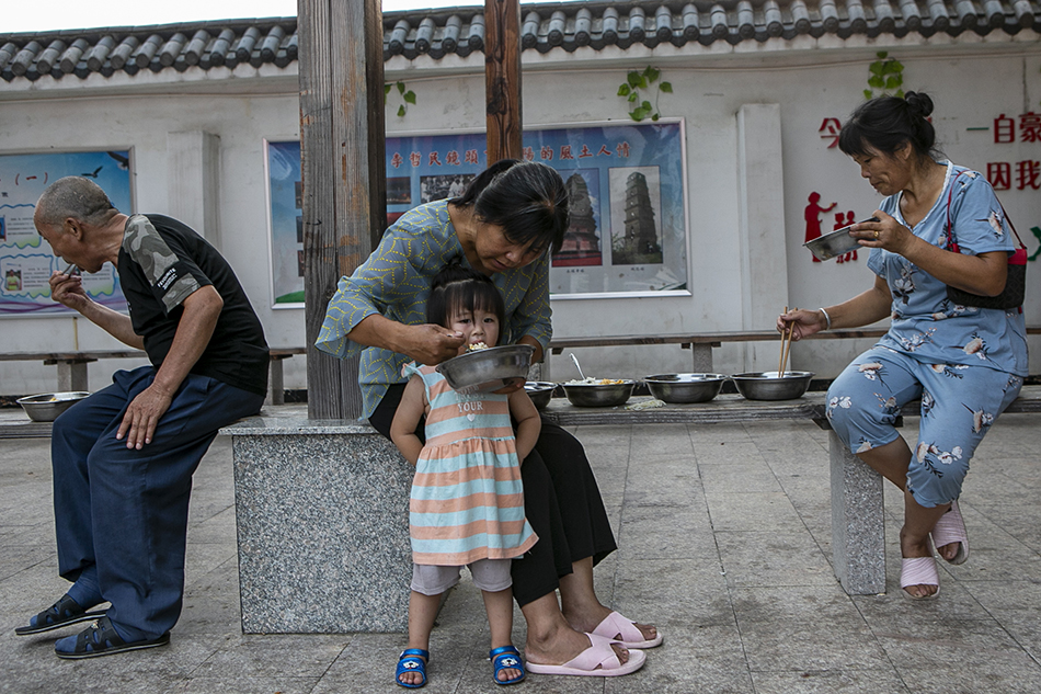 2020年7月16日，江西省鄱阳县五一中心学校安置点，安置点内的受灾民众在院子里吃饭。