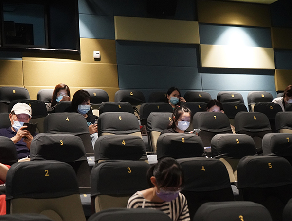 放映厅内,观众们戴着口罩,间隔两个座位就坐