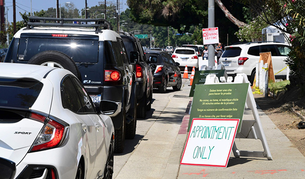 7月17日，人们驾车在美国洛杉矶一处免下车新冠病毒检测站外排队等待。新华社 图