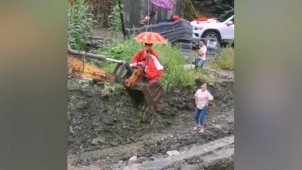 暴雨致道路阻断，十堰一对新人坐挖掘机过河结婚