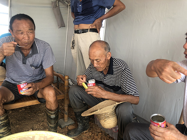 守堤村民巡查后回到帐篷休息,吹牛聊天