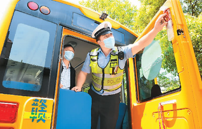 江西省宜春市上高县交警大队南港中队民警正在对幼儿园校车进行安全检查。 周亮摄（人民视觉）