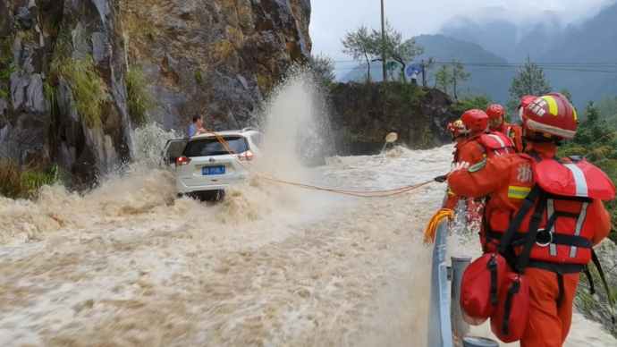 越野车被困，消防员用身体挡住水流救人