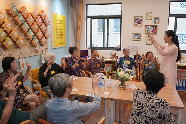 在长宁区虹桥街道社区综合为老服务中心的,九位有认知障碍老人正围坐在一起进行认知刺激训练。 澎湃新闻见习记者曹伊湄 图