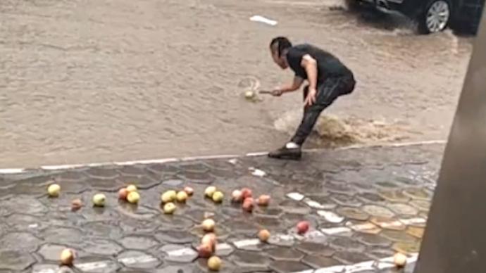 暴雨冲走一车苹果，男子站街边用漏勺打捞如数奉还