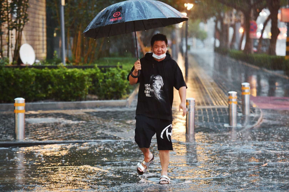傍晚降雨再来,蒲方路上行人打起雨伞.北京日报 图