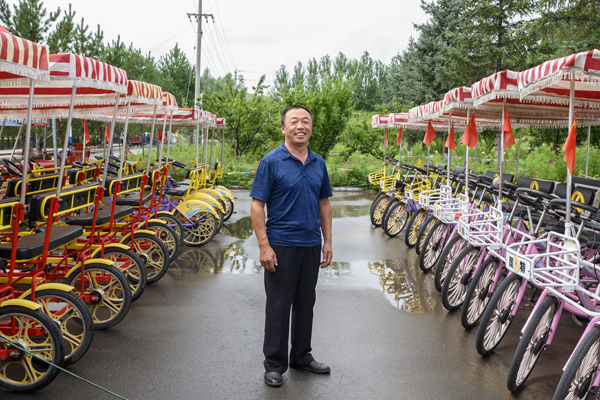 2020年8月，内蒙古兴安盟义勒力特嘎查，辛天喜站在自家的自行车队里。