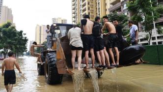 洪峰过境成都金堂县：街区被淹，有居民借助轮胎、挖掘机撤离