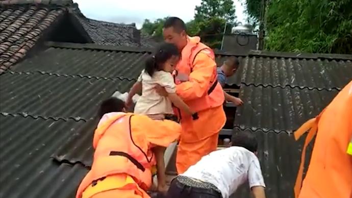 乐山洪水直逼屋顶，消防员揭房瓦救人