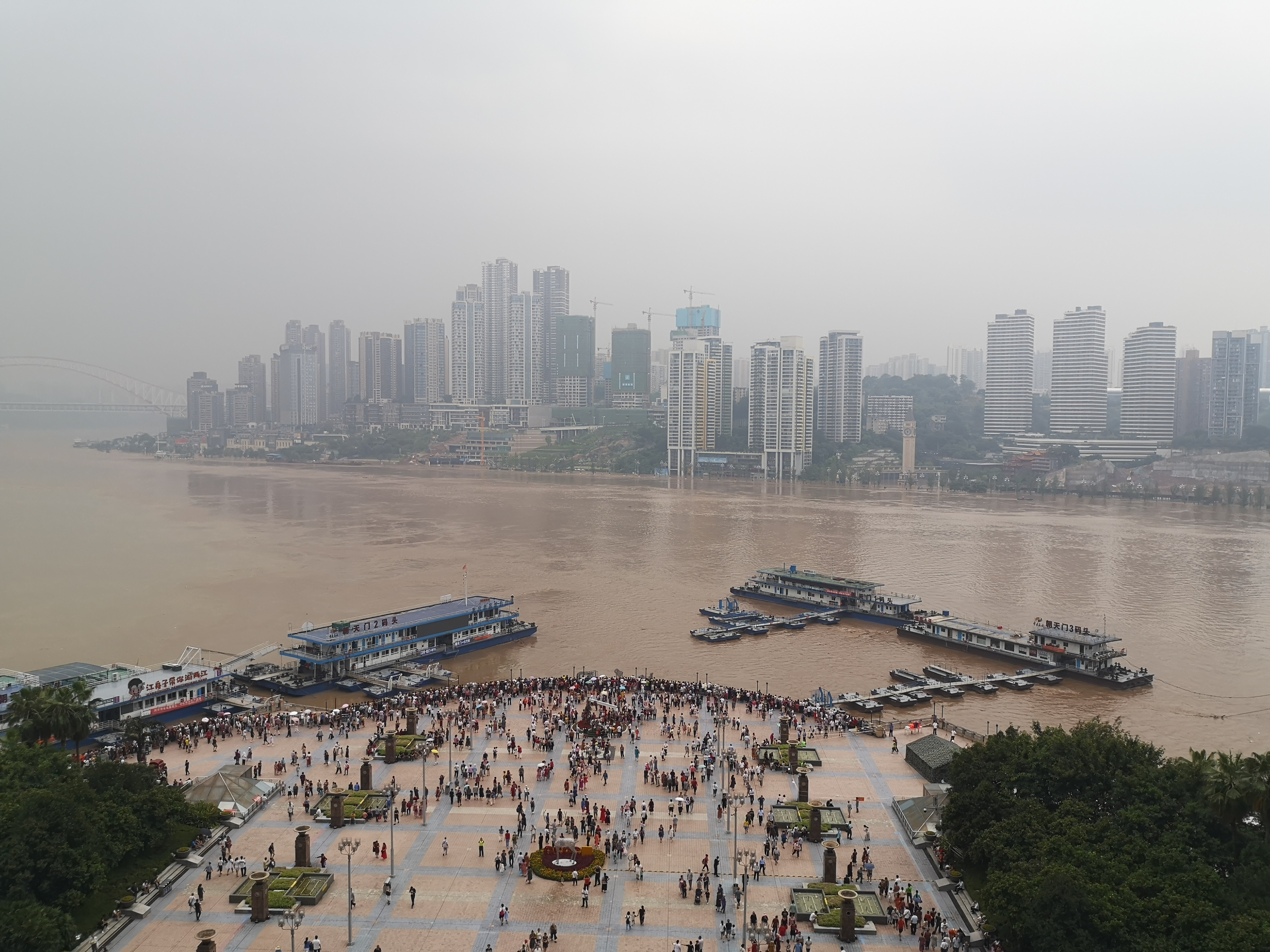 8月20日中午，重庆朝天门两江交汇处，不少市民在广场上看洪水。