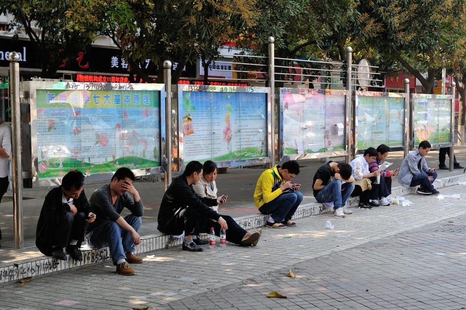 深圳龙华三和职介中心外面等待机会的青年人。