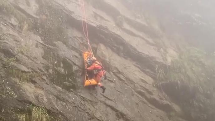 2名“驴友”坠崖被困22小时，救援队用绳索将担架拉上悬崖
