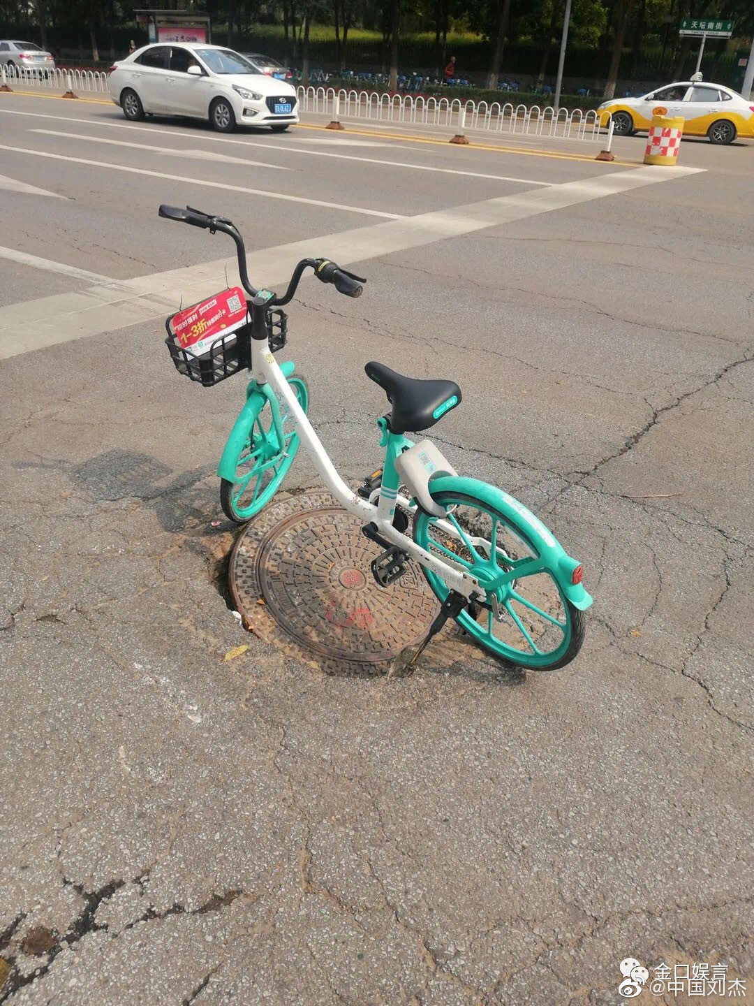 网传的图片显示，在一路口处，有一个已经松动的窨井盖，该井盖上方停有一辆共享单车。图片来源：微信公众号“金口娱言”