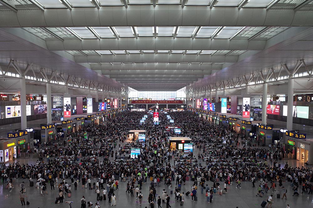 国庆前的虹桥火车站等着回家的人们抱着孩子提着月饼礼盒