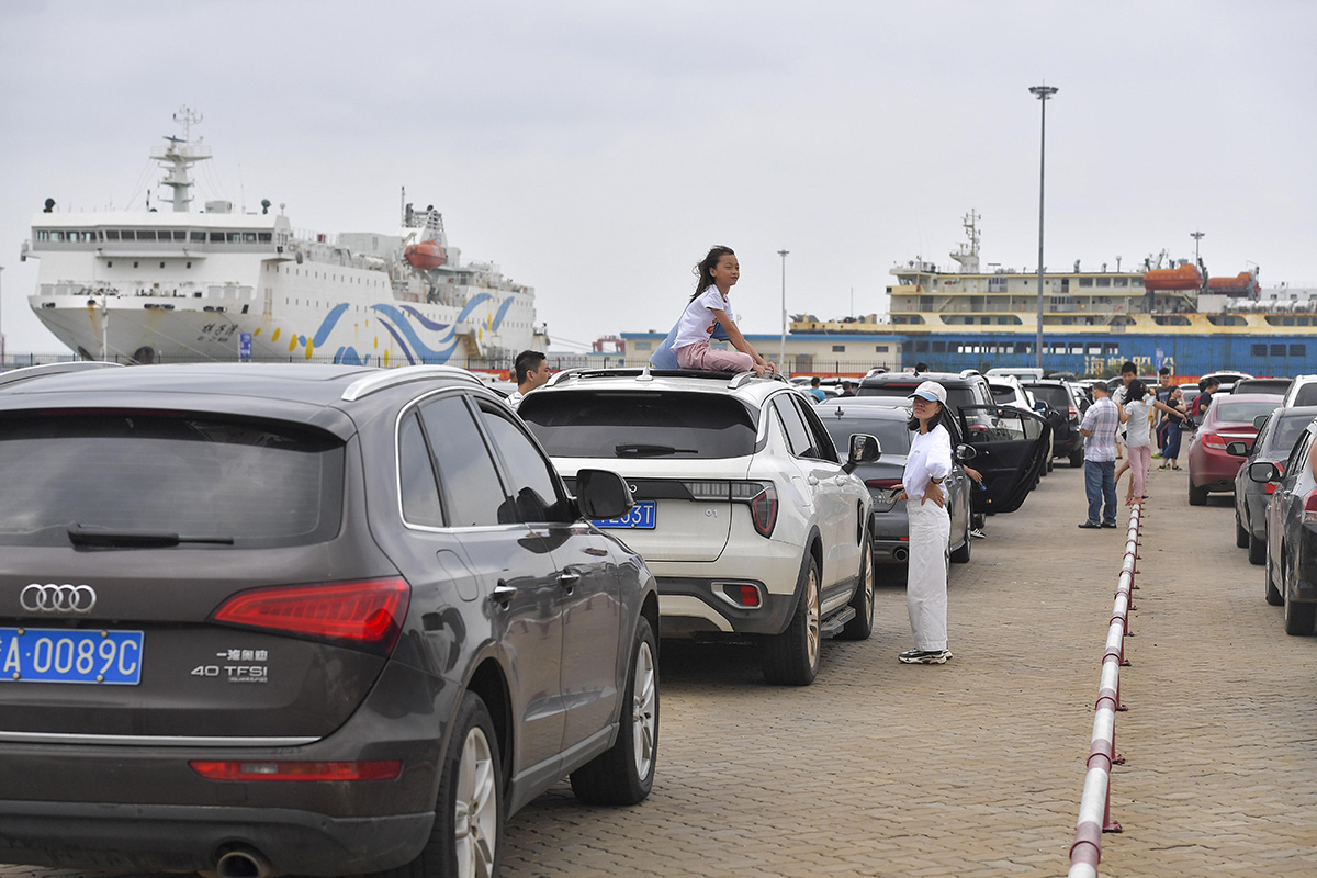 10月7日,在海南省海口市的新海港码头排队等待上船的自驾游客.