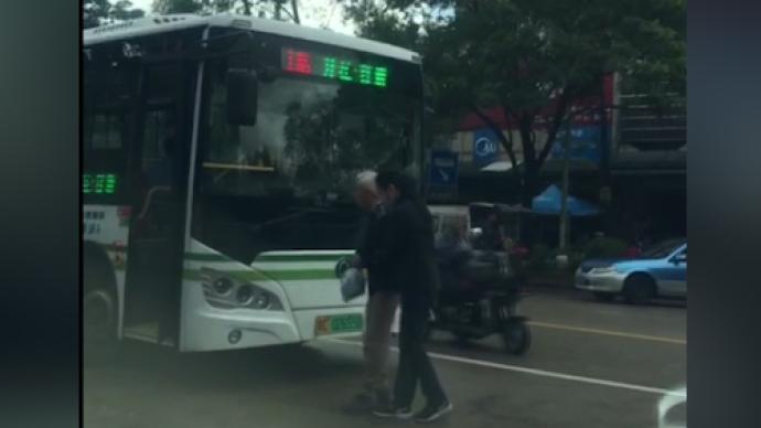 老人蹒跚过马路乘公交，热心女司机下车搀扶