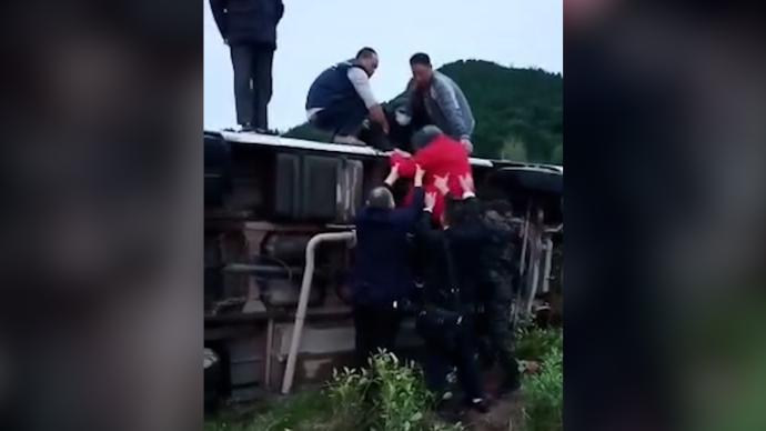 載客大巴車側(cè)翻，過路公交司機(jī)停車與乘客一同救援