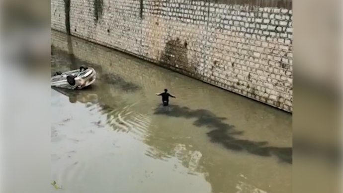云南昭通一汽车掉入河中反扣，市民合力将司机救出