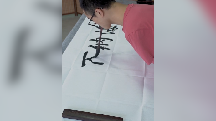 无臂小伙嘴咬毛笔写书法每天练数小时期间尽量不喝水