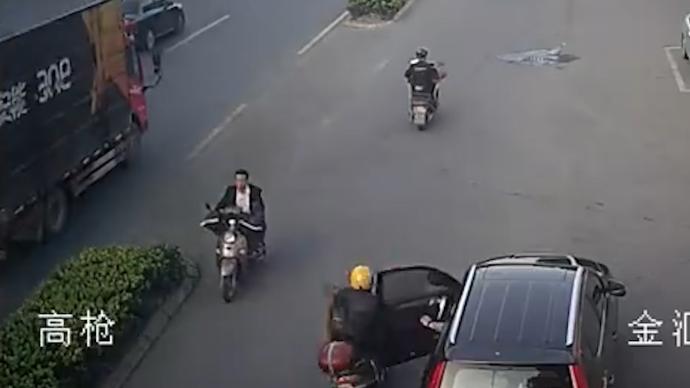 司机开车门与两辆电动车相撞，致两人受伤